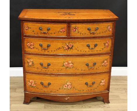 A Sheraton Revival style bow front chest of two short over three long graduated drawers, painted with a musical trophy and fl