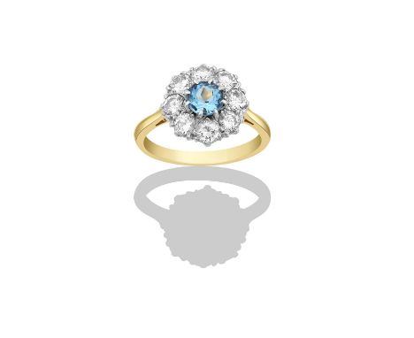 An Aquamarine and Diamond Cluster Ringthe round cut aquamarine within a border of round brilliant cut diamonds, in white claw