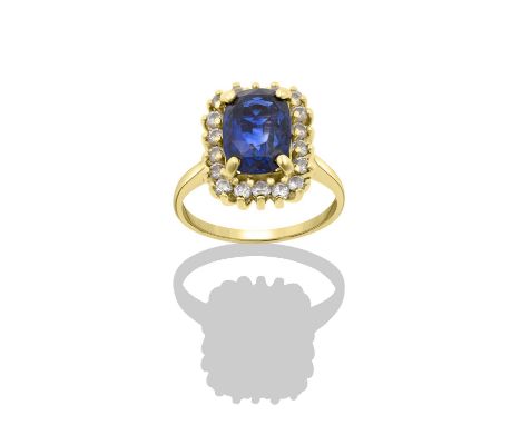 A Sapphire and Diamond Cluster Ringthe oval cut sapphire within a border of round brilliant cut diamonds, in yellow claw sett