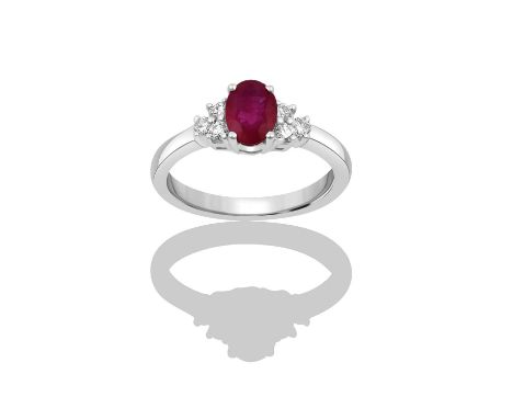 An 18 Carat White Gold Synthetic Ruby and Diamond Ringthe oval cut synthetic ruby flanked by trios of round brilliant cut dia