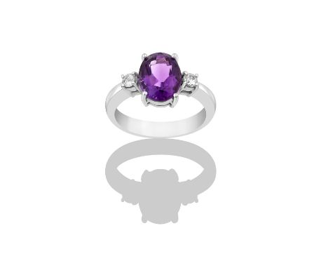 An Amethyst and Diamond Three Stone Ringthe oval cut amethyst flanked by round brilliant cut diamonds, in white claw settings