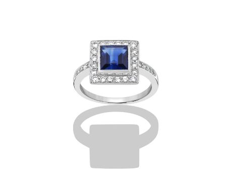 An 18 Carat White Gold Sapphire and Diamond Cluster Ringthe square step cut sapphire within a border of round brilliant cut d