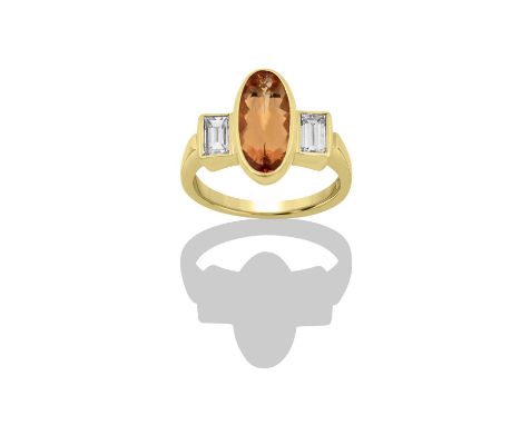 An 18 Carat Gold Imperial Topaz and Diamond Ringan oval cut imperial topaz flanked by baguette cut diamonds, in yellow rubbed