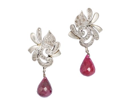 A PAIR OF RUBY AND DIAMOND DROP EARRINGS each comprising a stylised scrolling top set with single cut diamonds, suspending a 