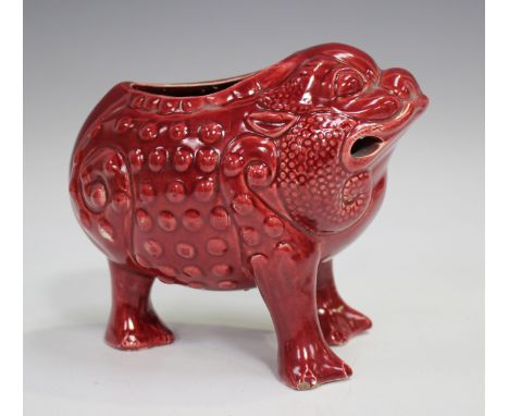 A Wardle ruby glazed pottery spoon warmer in the form of a three-legged grotesque toad, circa 1900, impressed mark to base, h