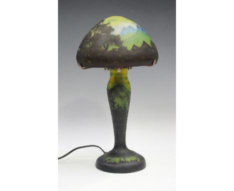 A Gallé type cameo style glass table lamp, modern, the domed shade decorated with houses in a mountainous landscape, the balu
