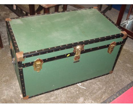 Vintage canvas trunk with carrying handles and metal mounts.