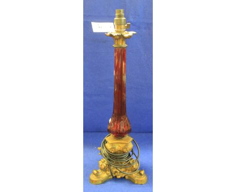 20th Century gilt metal ruby glass triform candle stick now converted to lamp base. CONDITION REPORT: Appears undamaged.