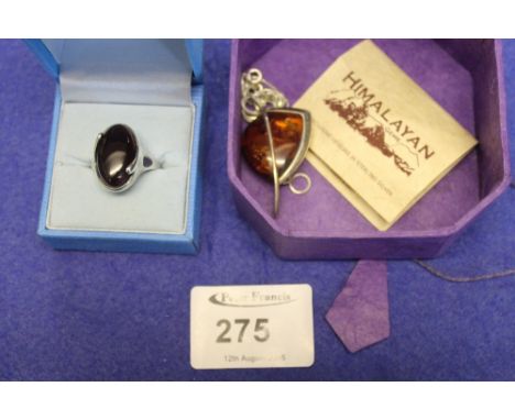 Silver and amber dress ring and similar silver mounted amber pendant.  (2)