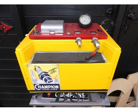A vintage spark plug testing machine, advertising Champion Spark Plugs