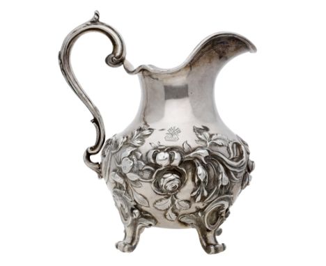 A Victoria silver cream jug, repoussé decorated in high relief with trailing flowers, with S-scroll handle, on voluted feet, 
