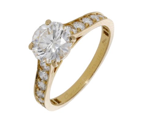 A diamond ring by Cartier, the principal brilliant-cut diamond, weighing 1.54 carats, between similarly-cut diamond-set shoul