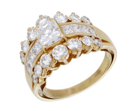 A diamond dress ring, set with a princess-cut diamond with similarly-cut diamonds to either side, between graduated brilliant