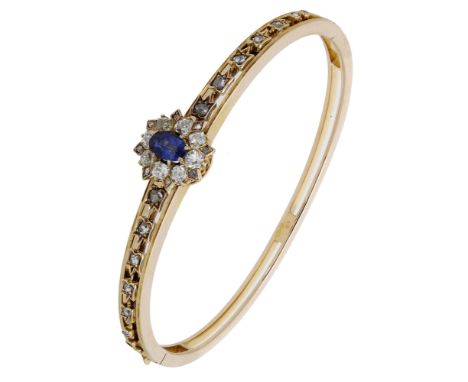 A late 19th century sapphire and diamond bangle, set to the front with a sapphire and old brilliant-cut diamond cluster betwe