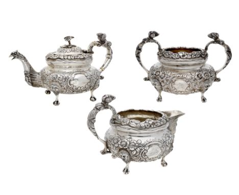 A matched Irish three piece tea service in mid 18th century style, ornately repoussé decorated with flowerheads and foliage, 