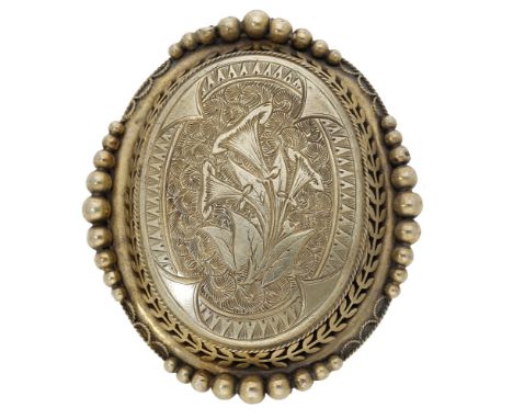A mid to late 19th century locket, the central panel with engraved foliate decoration and opening to reveal a glazed compartm