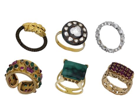 A collection of six gem-set rings, comprising a wirework crossover ring with dragon head motif terminals, an Indian diamond c