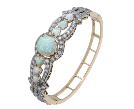 An opal and diamond bangle, set to the front with oval and heart-shaped opal cabochons, within an openwork surround of brilli