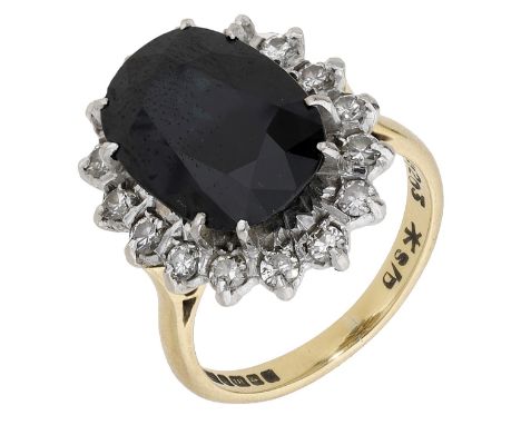An 18ct gold sapphire and diamond cluster ring, the large oval mixed-cut sapphire claw-set within a surround of brilliant-cut