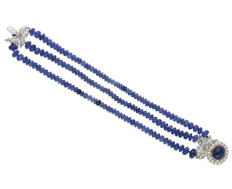 A sapphire and diamond bracelet, the three rows of polished sapphire beads leading to a cluster clasp with foliate detailing 