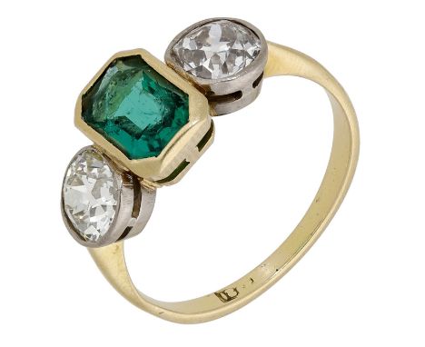 An emerald and diamond three stone ring, the step-cut emerald between two old brilliant-cut diamonds, stamped ‘18’, total dia