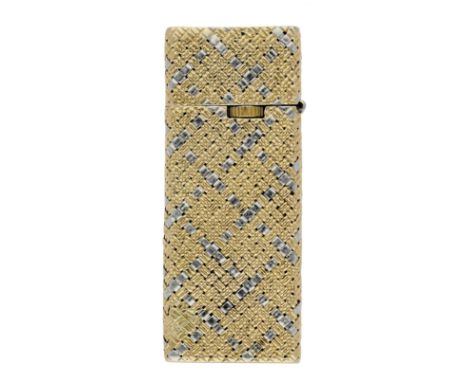 A bicoloured lighter, with weave textured surface, stamped ‘750’, height 5.9cm. £200-£300  ---  Condition Report Exterior in 