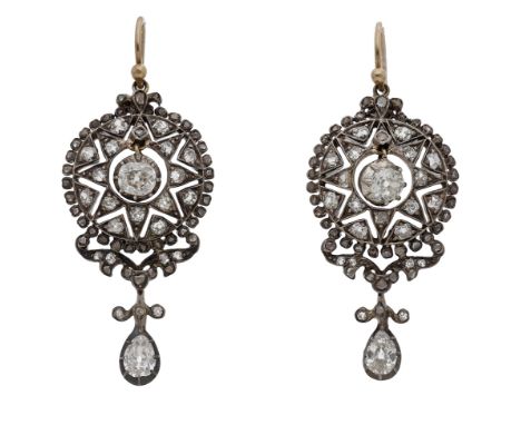 A pair of late 19th century diamond ear pendants, each set with an old brilliant-cut diamond within a pierced star surround s