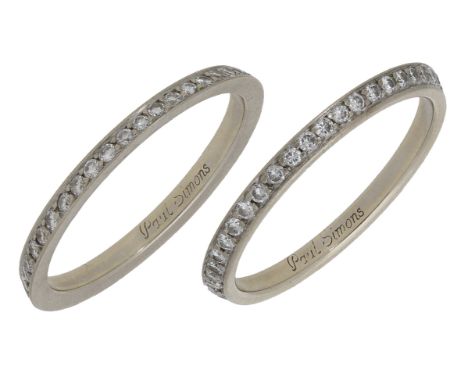 A pair of diamond eternity rings by Paul Simons, each angled to create illusion of a single ring, set throughout with brillia