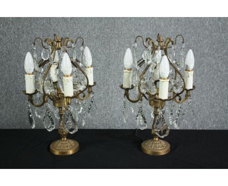 A pair of mid-century candelabra type brass table lamps. Decorated with hanging teardrops and star shaped crystal glass. Each