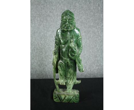 A 20th century carved spinach jade figure of a Chinese elder. H.43cm. 