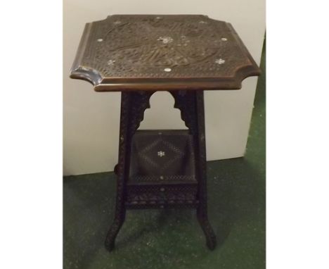 Late 19th or early 20th century Moorish style table, with heavily carved top with mother-of-pearl inlay, supported on four ca