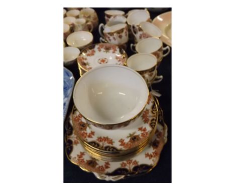 Early 20th century English part tea set, with gilded and rust floral decorated rims, comprising twelve teacups and eleven sau