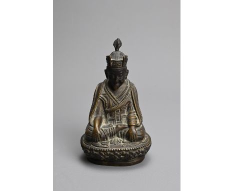 A TIBETAN BRONZE FIGURE OF SHAMARPA LAMA. Seated in meditation, wearing monastic robes and a Kagyu style hat, on a stylised l