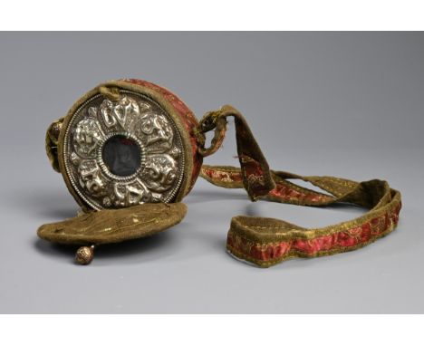 A TIBETAN WHITE METAL AND COPPER GAU BOX, EARLY 20TH CENTURY. Of circular form with central Buddha encased in an amulet box. 