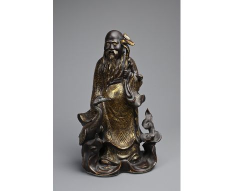 A CHINESE BRONZE IMITATION PORCELAIN FIGURE OF SHOULAO, YOU CHANGZI (1874-1922). The brown glazed and gilt decorated porcelai