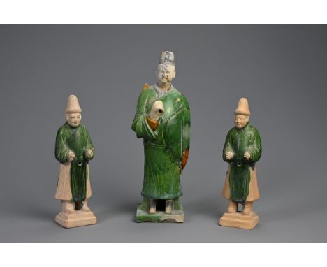 THREE SANCAI AND GREEN GLAZED POTTERY MODELS OF ATTENDANTS, MING DYNASTY (1368-1644). Dressed in robes on square form bases. 