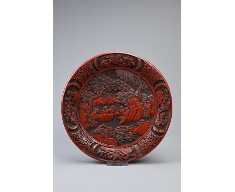 A CHINESE CARVED CINNABAR LACQUER DISH, 19TH CENTURY. Carved in relief with scholars in landscape scene with rockwork and pin