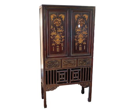 A 20TH CENTURY CHINESE RED STAINED CARVED GILTWOOD KITCHEN CABINET. The double doors carved with bats flanking pierced foliat