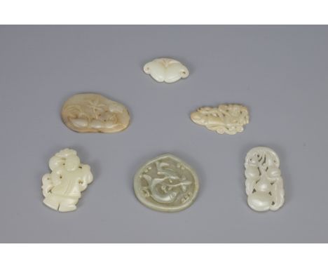 SIX CHINESE CARVED PALE CELADON JADE PENDANTS, of different forms to include hanging double-gourds, boy holding lingzhi fungu