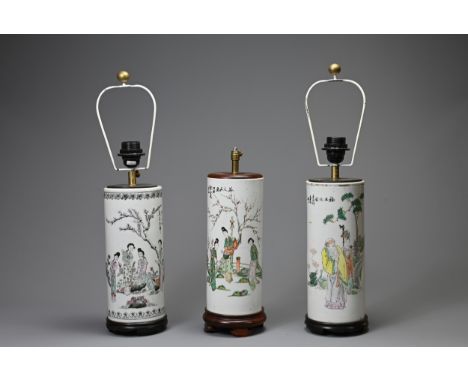 THREE 20TH CENTURY CHINESE PORCELAIN SLEEVE VASES ADAPTED AS LAMPS. The first painted in the famille verte palette with ladie