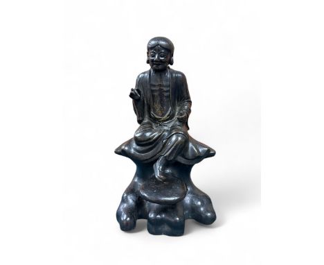 Chinese late Ming Period,Hollow cast patinated bronze figure of Lohan holding a scribe tool,Seated on detachable rock base wi