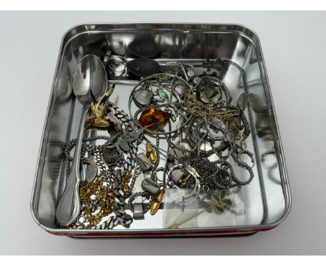 A tin containing silver and costume jewellery including a silver and ammonite bracelet, an amber pendant etc