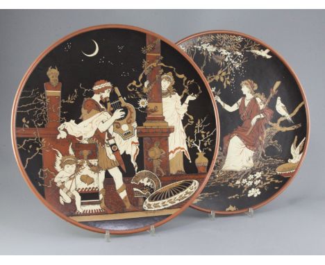 Heinrich Schlitt for Mettlach - two stoneware chargers, c.1900, the first decorated with a Greek goddess and a satyr, initial
