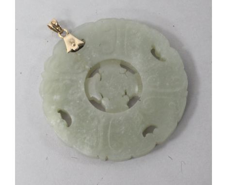 A gold mounted circular carved jade pendant, 2in.