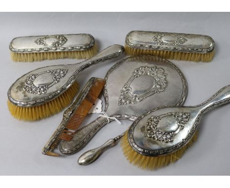 A George V silver mounted six piece brush and mirror set and a silver mounted button hook.