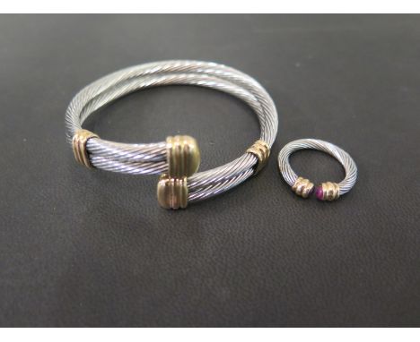 A bi-colour metal crossover style bangle - Together with a similar torque-style ring set with cabochon rubies - Ring size K
C