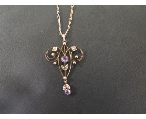 An early 20th century 9ct gold amethyst and seed pearl openwork pendant - Suspended from a fancy-link chain - Stamped 9c - Le