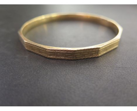 A 9ct gold faceted slave bangle - With Greek Key detail - Hallmarked Birmingham - Inner diameter 7cms - Weight approx 10.2gms