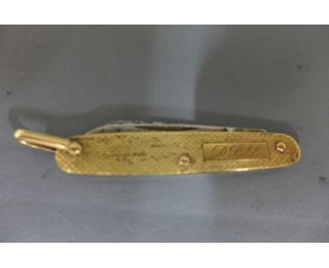 A 9ct yellow gold cased pairing knife with engine turned decoration and monograme for D.R.B. marked 1954 London 