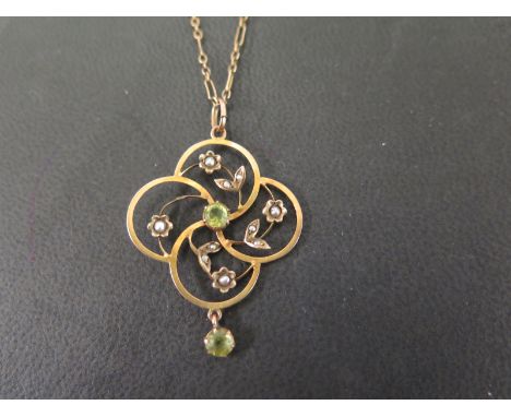 An early 20th century 9ct gold peridot and seed pearl pendant - Suspended from a fancy-link chain - Length of pendant 4cms - 